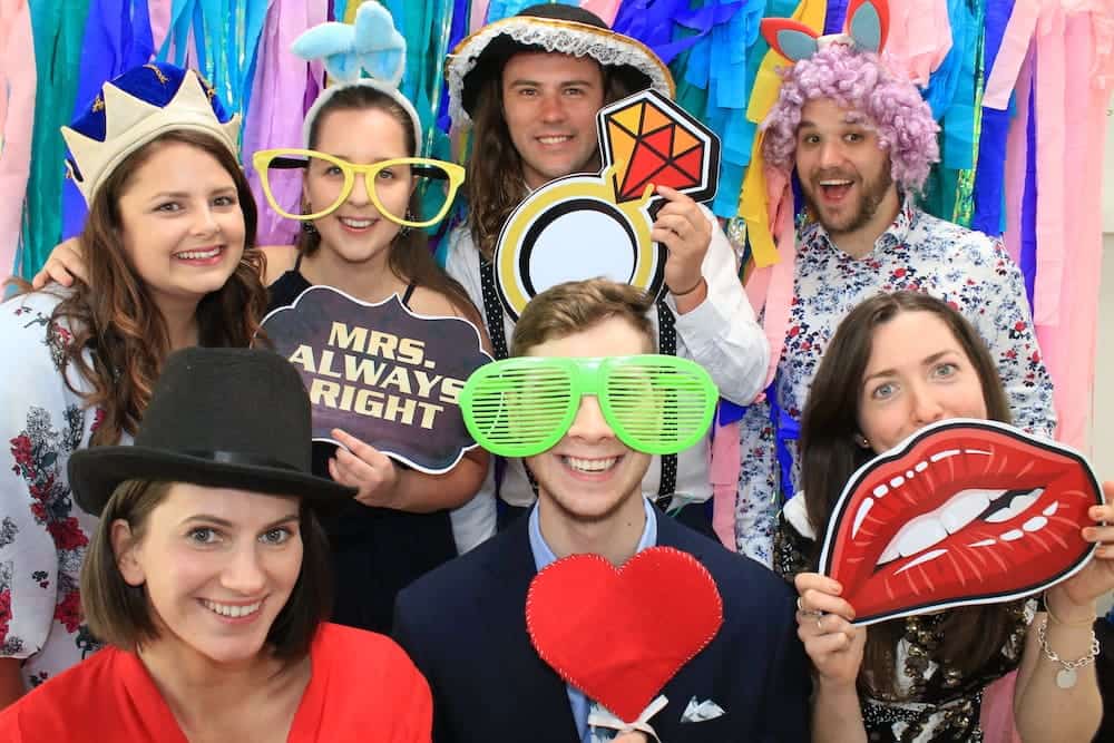 Guests with props at an open-air photo booth